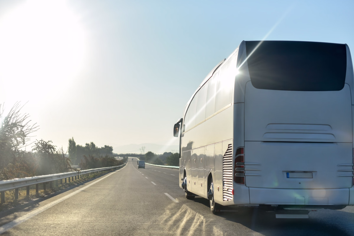 Ein fahrender weißer Bus von hinten